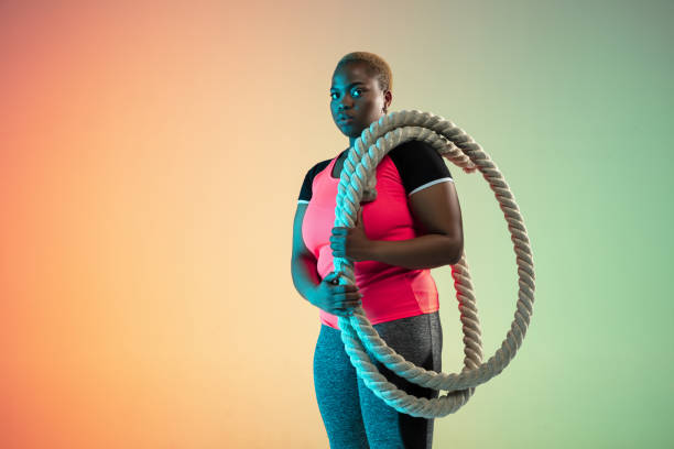 istock Young african-american plus size female model's training on gradient background 1214913768