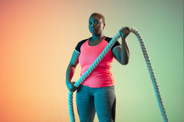 istock Young african-american plus size female model's training on gradient background 1214913776