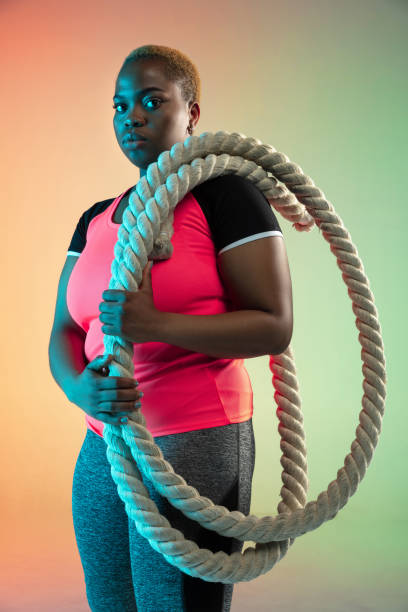 istock Young african-american plus size female model's training on gradient background 1214913777