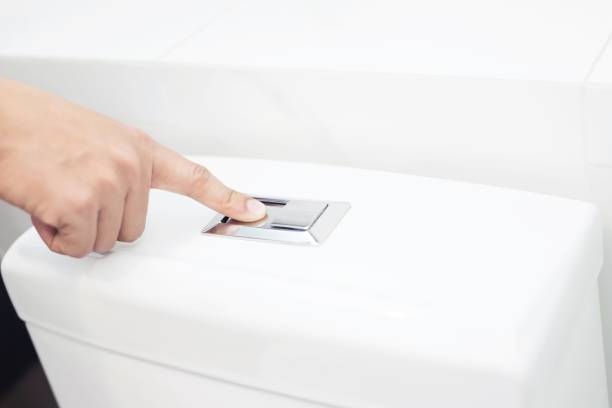 istock A man's hand pressing the power button Toilet bowl 1214913828