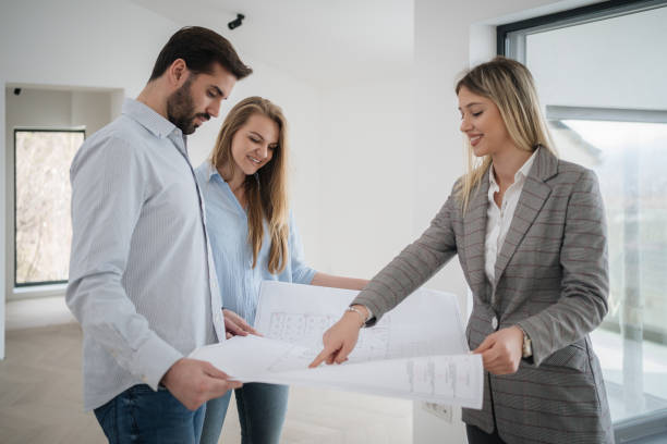 istock Young couple are examining blueprint with an architect 1214913858