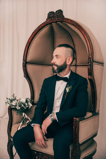 istock brooding groom waiting for his bride sitting in a chair 1214914365