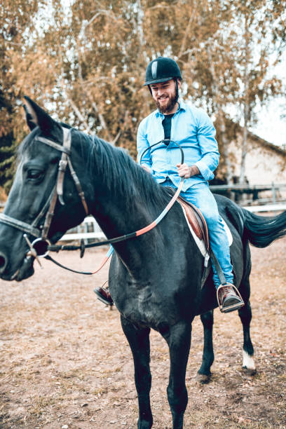 istock Male Jockey Ready To Start His Training With Black Mare 1214916147