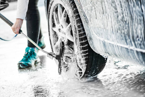 istock Woman is washing a car using high pressure water. 1214918785