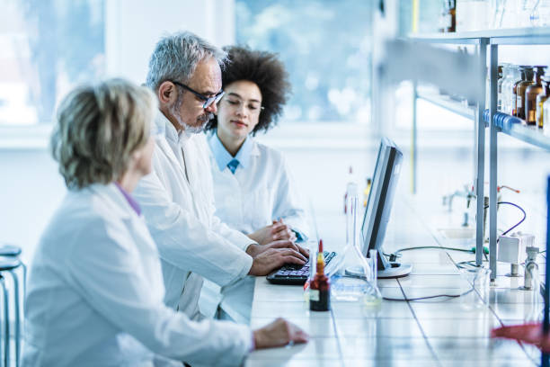 istock Team of biotechnologists working on desktop PC in laboratory. 1214918931