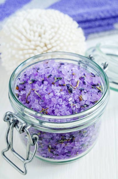 Glass jar with purple bath salt (foot soak) wirh dry lavender.
