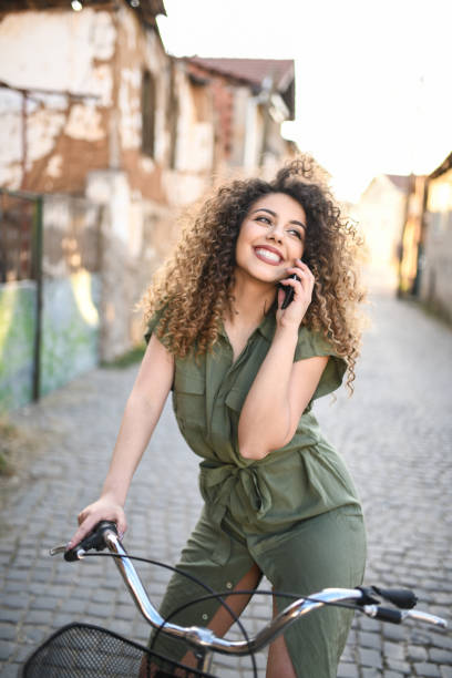 istock Female Riding Bicycle And Talking On Smartphone 1214919390
