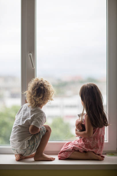 istock Brother and sister play with a cat 1214919492