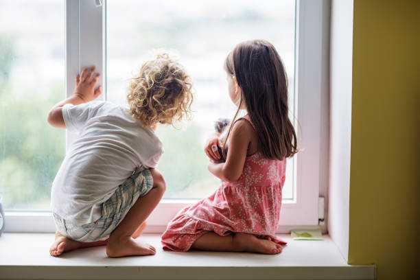 istock Brother and sister play with a cat 1214919493