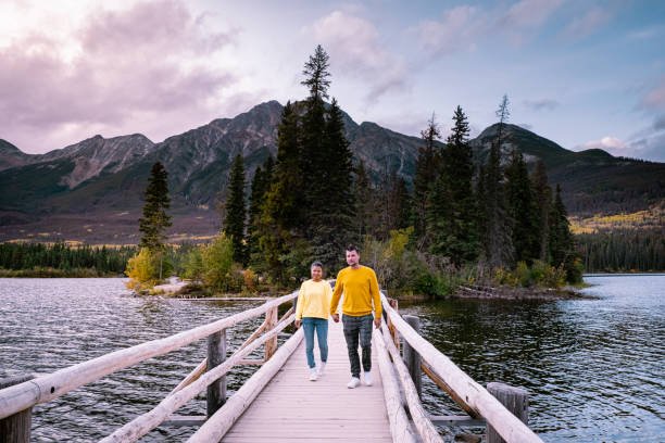 istock couple by the lake watching sunset, Pyramid lake Jasper during autumn in Alberta Canada, fall colors by the lake during sunset, Pyramid Island Jasper 1214926062