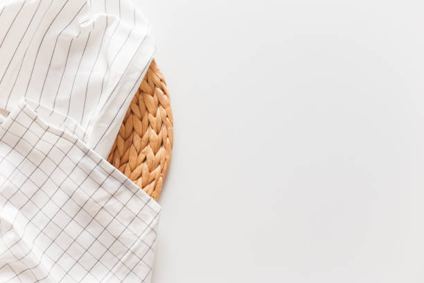 istock White striped and checkered tablecloth and wicker placemat close-up, isolated on white with copy space. 1214926161