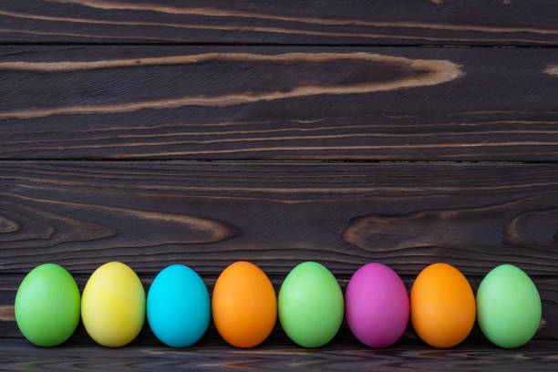 istock Painted colorful Easter eggs on dark wooden boards. Paschal template with text space. Holiday greeting card in laconic style. 1214927285