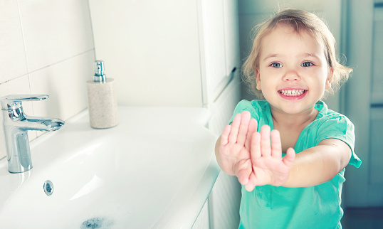 Caucasian child girl showing clean washed hands,kid washing hands in bathroom.