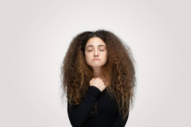 istock Young women praying over isolated grey background 1214930278