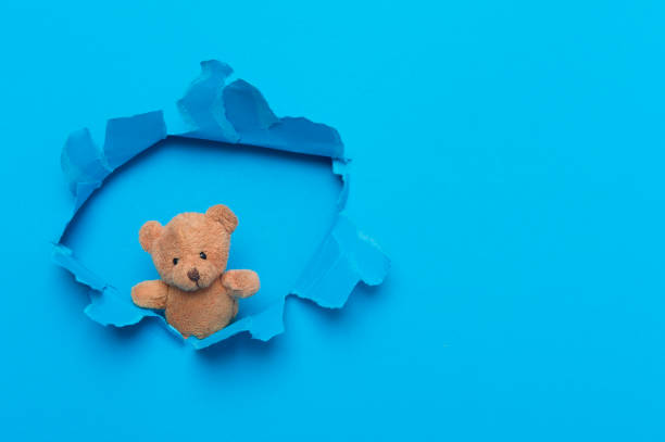 istock Teddy Bear In Paper cut hole. World Autism Awareness. 1214932165