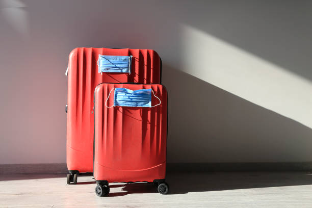 Two red luggages with protective masks. stock photo