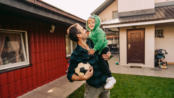 istock Father and son playing soccer in a yard 1214933007