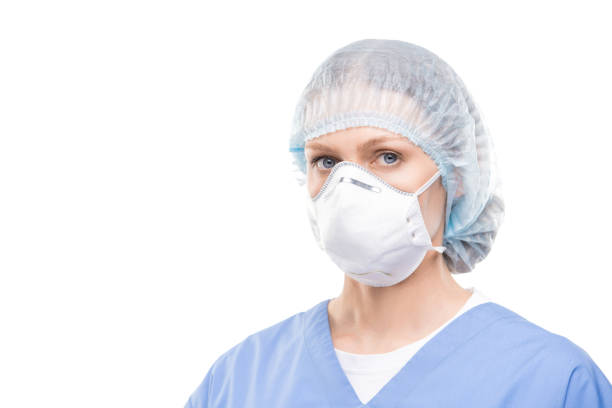 保護マスクと制服を着た現代の若い女性医師または看護師 - scrubs surgeon standing uniform ストックフォトと画像