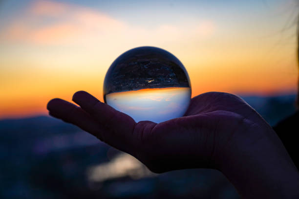 istock woman's hand with crystal ball Sunset 1214933869