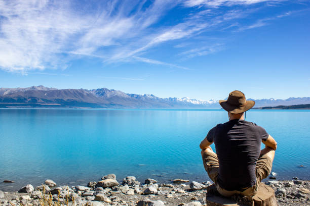 young causacian man enyoing view of Lake Pukaki with Mt Cook as a Background, South Island New Zealand ,Summertime View of Lake Pukaki with Mt Cook as a Background, South Island New Zealand mt cook photos stock pictures, royalty-free photos & images