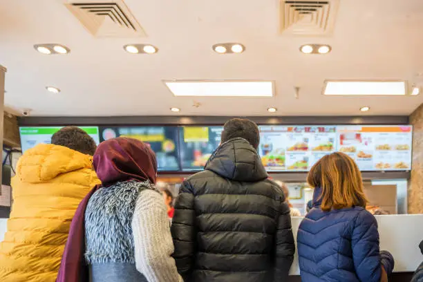 People waiting and queuing for order some food and make payment in Fast food Store.