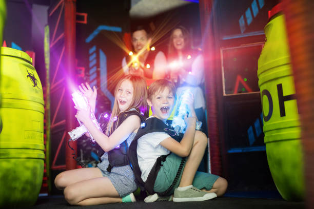 istock Kids sitting back to back on beams with laser pistols 1214934903