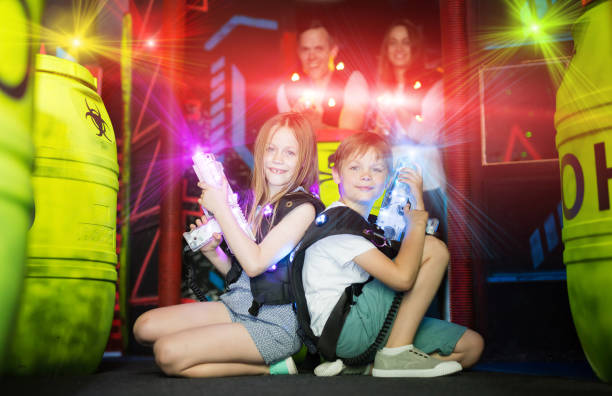 Kids sitting back to back in laser beams