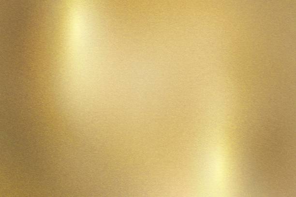 Light shining down on gold metal plate with copy space, abstract texture background stock photo