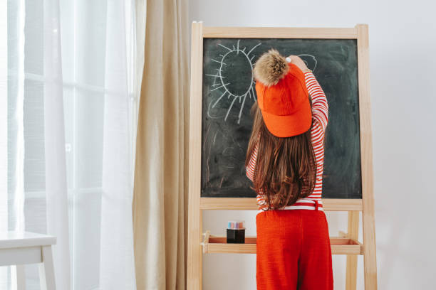 istock Little girl drawing on the blackboard 1214935296