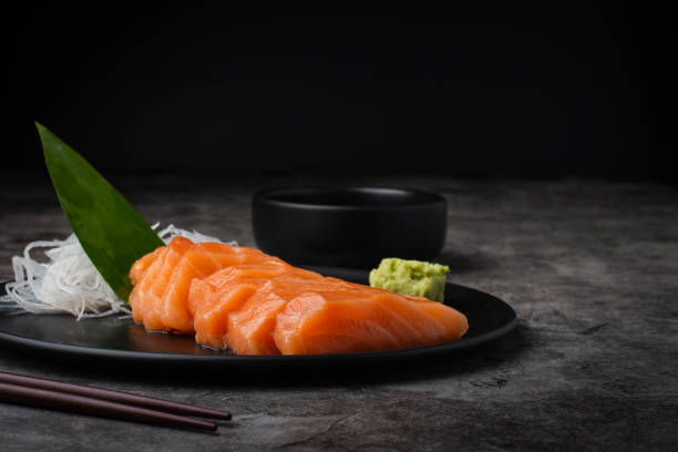 slice salmón / sasimi sobre fondo oscuro comida japonesa popular, salmón fresco sasimi situado en el restaurante japonés. - sashimi fotografías e imágenes de stock