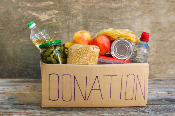 scatola di donazione con cibo su vecchio sfondo di legno - oil distribution foto e immagini stock