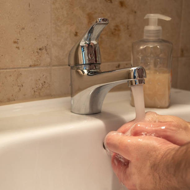 istock Careful washing hands with liquid soap in the restroom as prevention measures from coronavirus pandemic outbreak worldwide, with copy space, closeup, details 1214937129