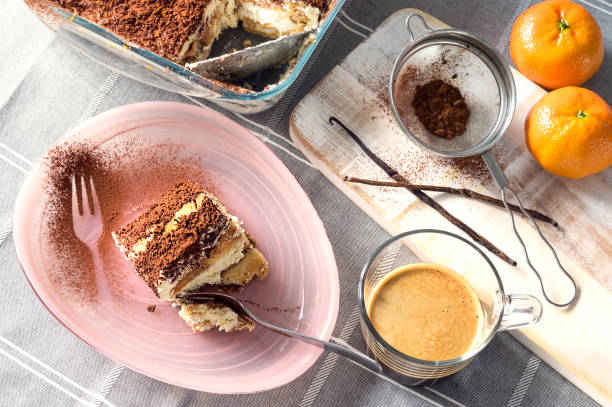 традиционный итальянский торт тирамису, приправленный кофе, ванилью и увенчанный шоколадом и какао-порошком - biscotti orange italian culture dessert стоковые фото и изображения