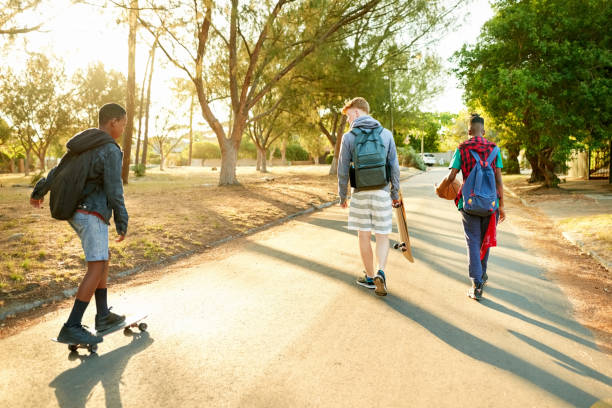 istock Teens skateboarding on the road 1214938303