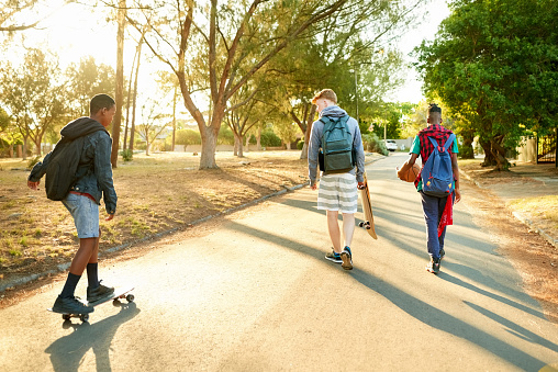 Teens skateboarding on the road