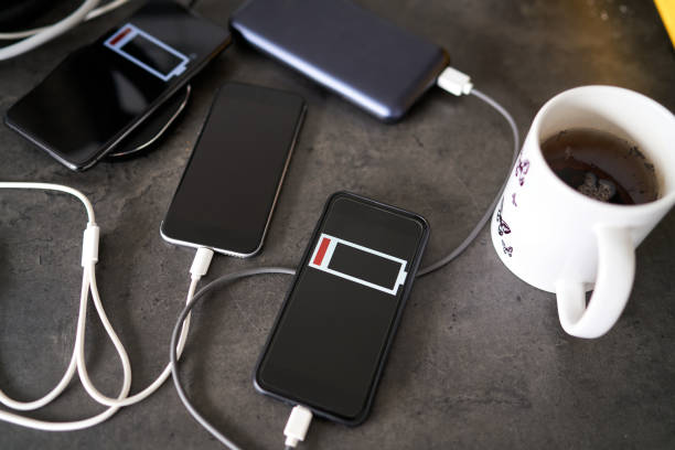 istock Three mobile phones charging black stone desktop，Charge sharing 1214942098