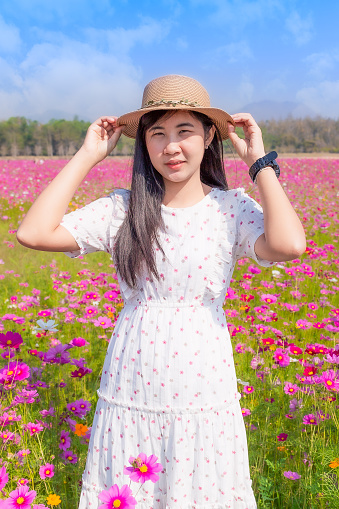 Woman in a pink dress in a field with pink flowers