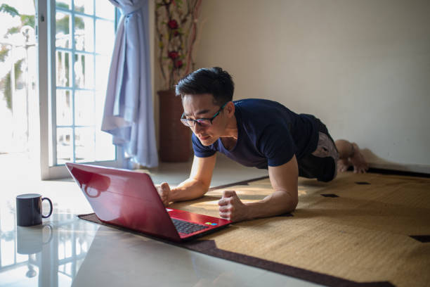 азиатский китайский бизнесмен работает из дома. планка тренировки и работы в то же время - ding стоковые фото и изображения