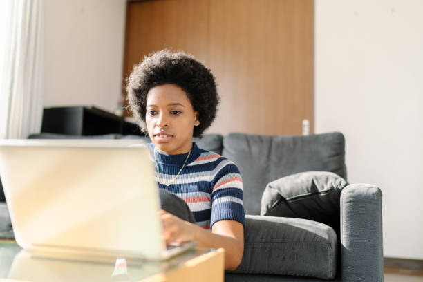 istock Young woman using laptop at home 1214942760