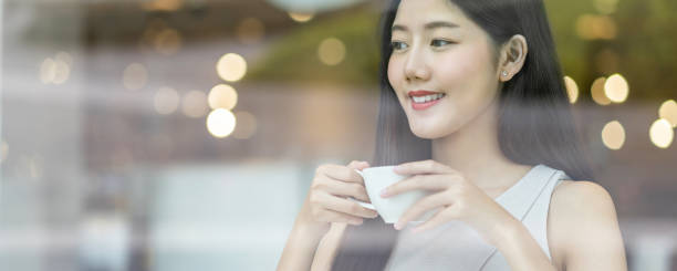 istock Smiling Young Woman Having Coffee Seen Through Glass 1214944213