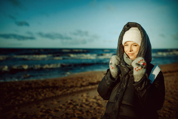istock Young woman at the beach on a cold, windy day. 1214946854