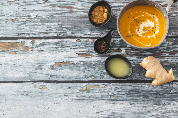 Pumpkin and carrot soup with ginger Pumpkin and carrot soup with ginger on wooden background squash soup stock pictures, royalty-free photos & images