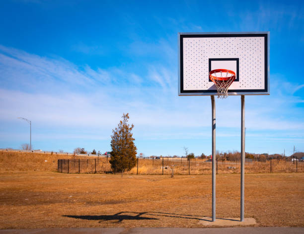 Basketball hoop at marina park on blue cloudy sky backgrounds, front view Basketball hoop on rest area neighborhood off-highway on a sunny day asphalt basketball court stock pictures, royalty-free photos & images
