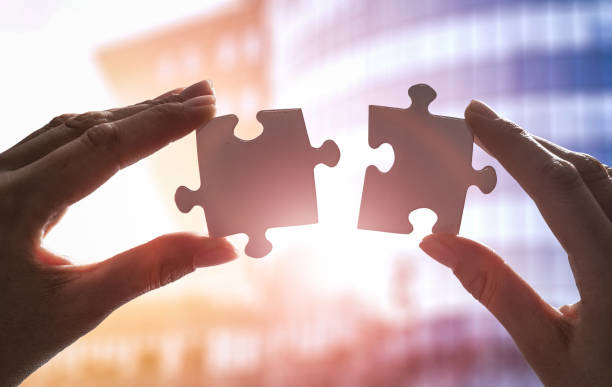 The man holds in his hand a jigsaw puzzle.
