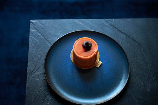 Slate coffee table with blue plate. Tasty looking orange cake ready for coffee break.