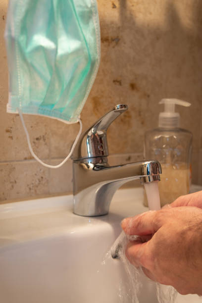 istock Washing hands with liquid soap in the restroom as prevention measures from coronavirus pandemic outbreak worldwide, with copy space and medical mask, closeup, details 1214952321