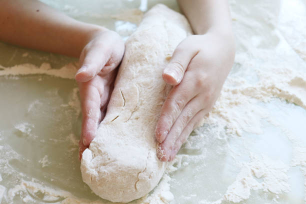 istock Making dough from flour. The child kneads the dough closeup 1214954981