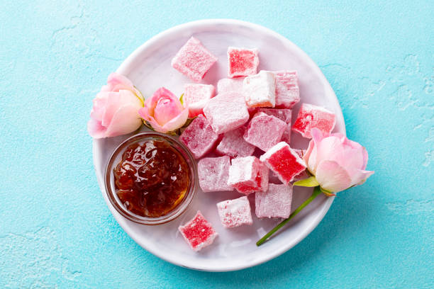 istock Turkish delight lokum, rose flavour in a white plate. Blue background. Top view. 1214956769