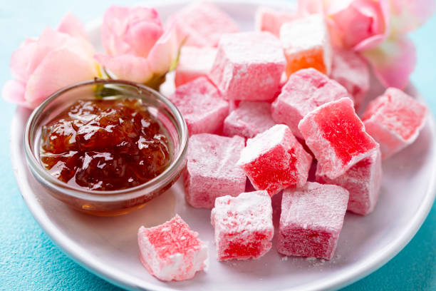 istock Turkish delight, rose flavour in a white plate. Blue background. Close up. 1214957509