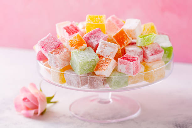 istock Assorted Turkish delights on glass cake stand. Pink background. Close up. 1214957859